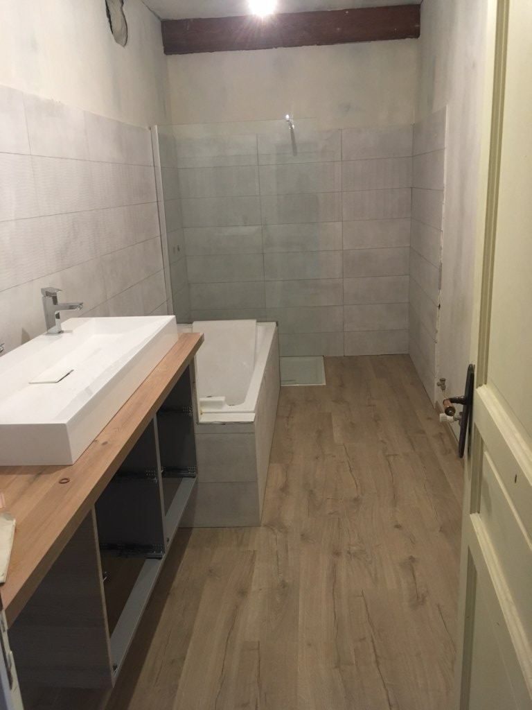 Salle de bain rénovée avec baignoire et carrelage